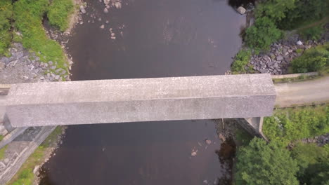 Aerial-shot-looking-straight-down-over-the-Piscataquls-River-and-the-lowes-covered-wooden-bridge-in-Maine