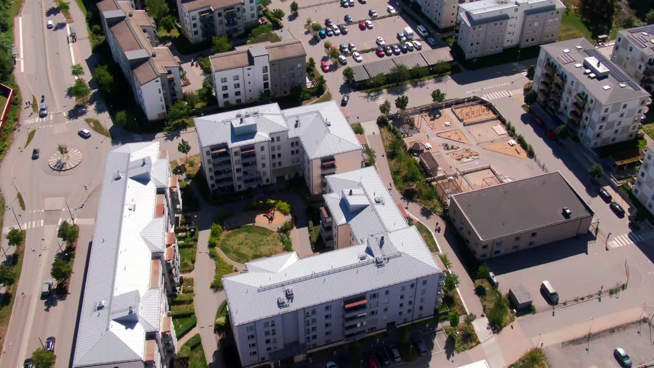 Ripresa aerea con drone di moderni complessi di appartamenti con parco giochi centrale e parcheggio nella zona residenziale di Gustavsberg. Perfetta per immagini di vita urbana familiare