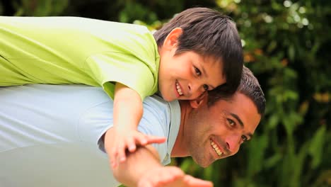 Man-playing-aeroplanes-with-his-son-on-his-back