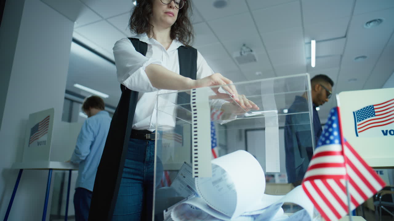 Caucasian Woman Puts Voting Bulletin in Box at Polling Station Multiethnic Voters American Citizens Vote for Future President in Voting Booths at Polling Station Caucasian Woman Puts Bulletin in Box Elections Day in the United States of America Slow Motion