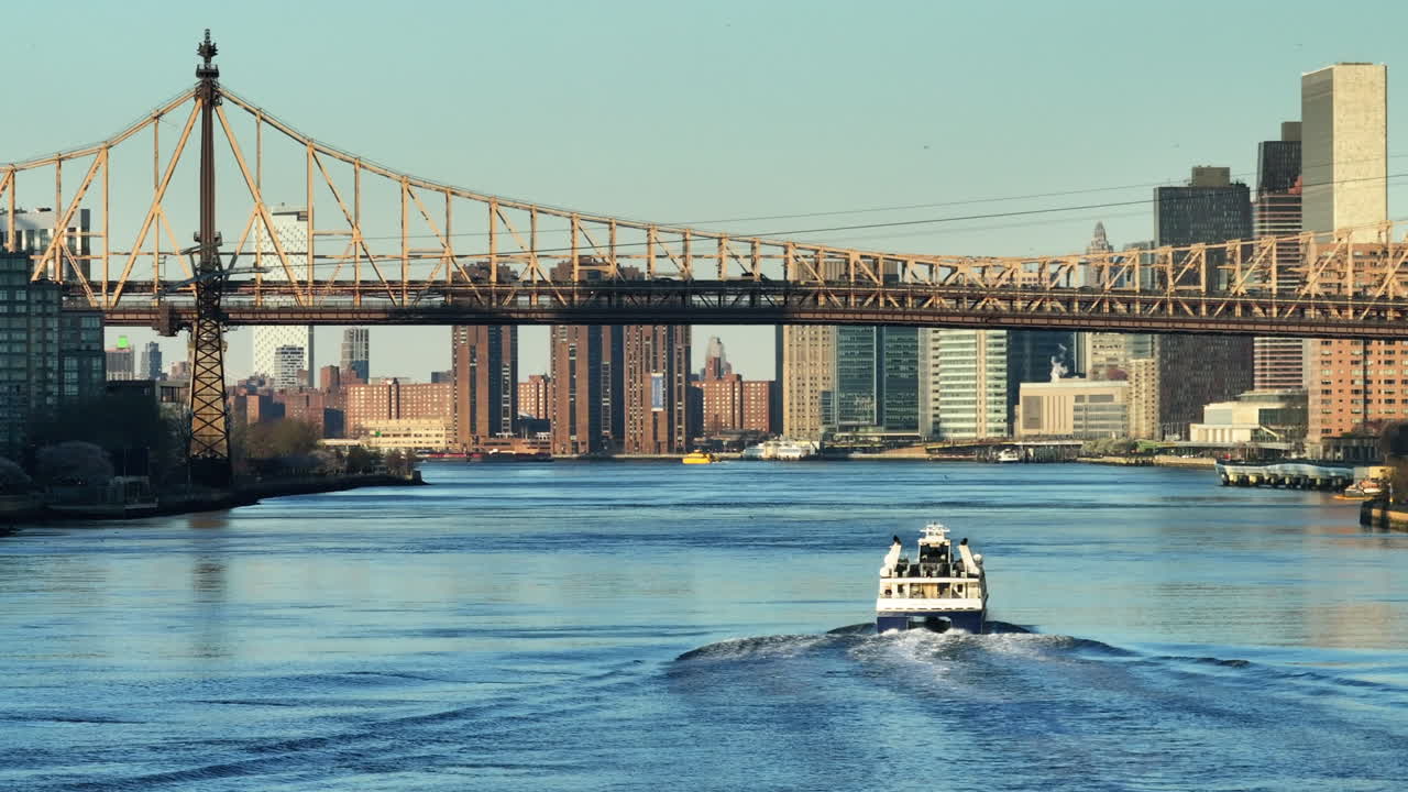 Aerial view of a ferry on New York City's East River. Shot at sunrise