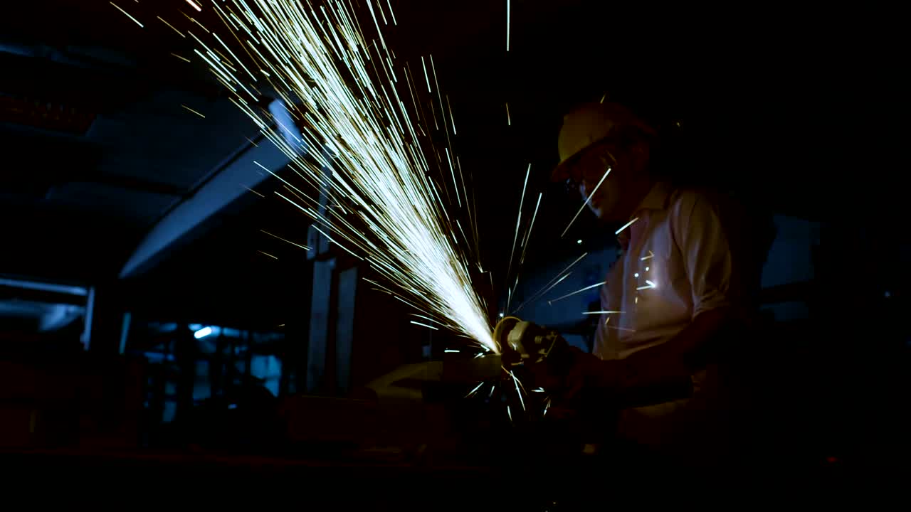 Young engineering  is cutting metal with angle grinder in workshop