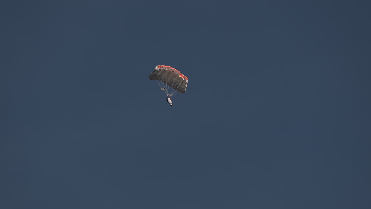 Wingsuit BASE jumper flying over Verbier surrounded by alpine mountains with snow-covered peaks. High-speed flight, dramatic scenery, and cinematic extreme sports action in the Swiss Alps.