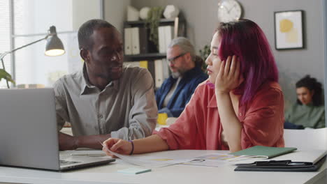 Afroamerikanischer-Mentor,-Der-Mit-Einer-Asiatischen-Praktikantin-Im-Büro-Arbeitet