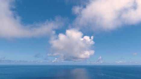 Sich-Schnell-Bewegende-Wolken-Im-Zeitraffer-über-Dem-Offenen-Blauen-Ozean-Mit-Reflexionen-Von-Wolken-Im-Wasser---Push-in-Dolly-Aufnahme