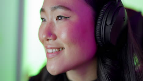 Asian,-woman-and-gamer-with-headphones-with-smile