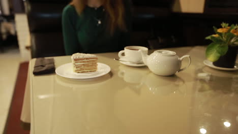 young woman sitting and eating dessert in cafe