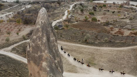 caravan of horses in scenic cappadocia landscapes in turkey - aerial drone shot