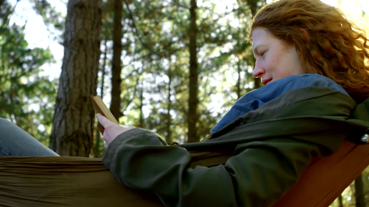 mujer leyendo un libro en el bosque 4k