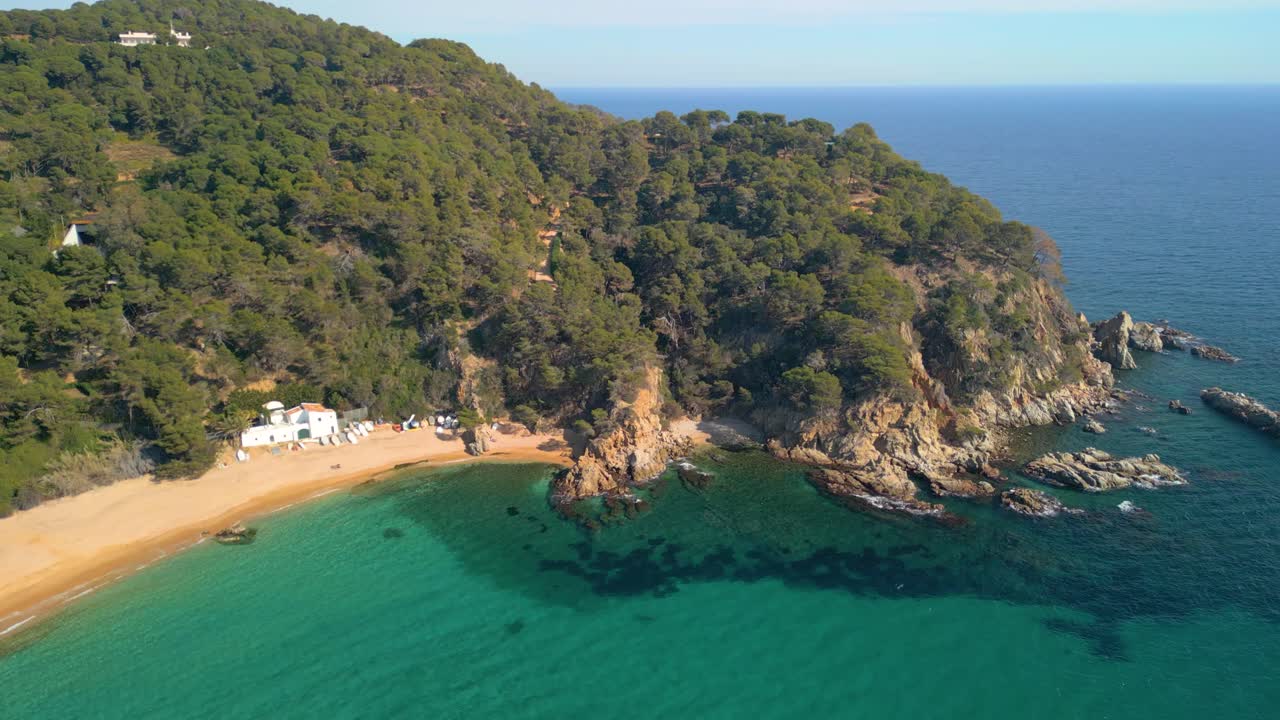 las imágenes tranquilas del dron te invitan a sumergirte en la belleza de lloret de mar y la tranquilidad de cala canyelles, en medio del escarpado paisaje de la costa brava.