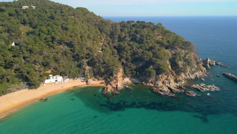 Las-Tranquilas-Imágenes-De-Drones-Te-Invitan-A-Sumergirte-En-La-Belleza-De-Lloret-De-Mar-Y-La-Tranquilidad-De-Cala-Canyelles,-En-Medio-Del-Paisaje-Accidentado-De-La-Costa-Brava.