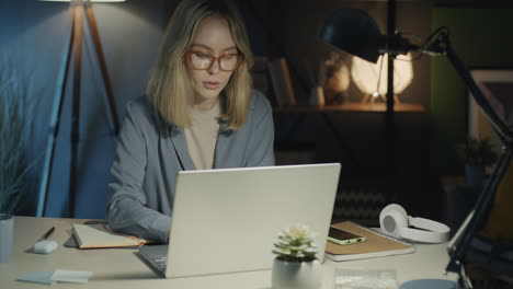 mujer trabajando tarde en la noche en la computadora portátil en la oficina de casa