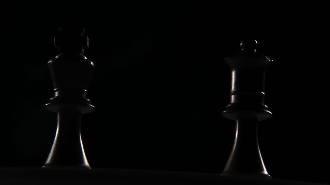 toma cinematográfica de una dama negra y una pieza de ajedrez rey
