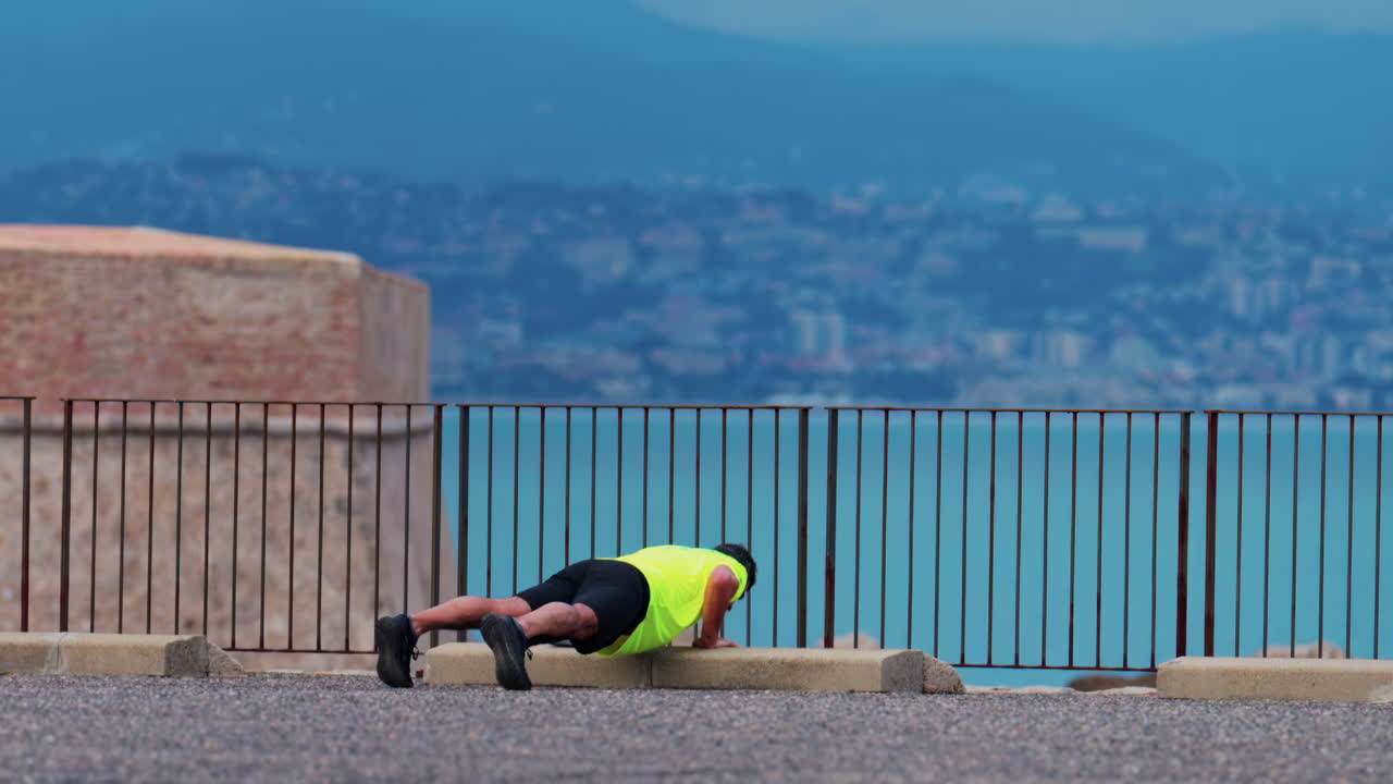 Man working out near the sea in Antibes, France with the city and the mountains on the background