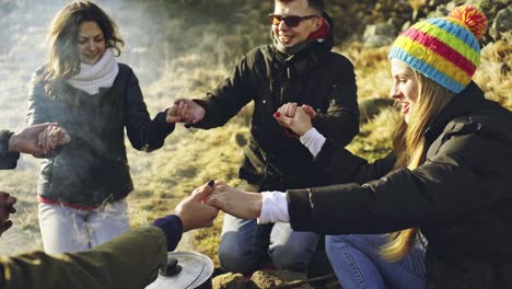 group of friends singing around the campfire