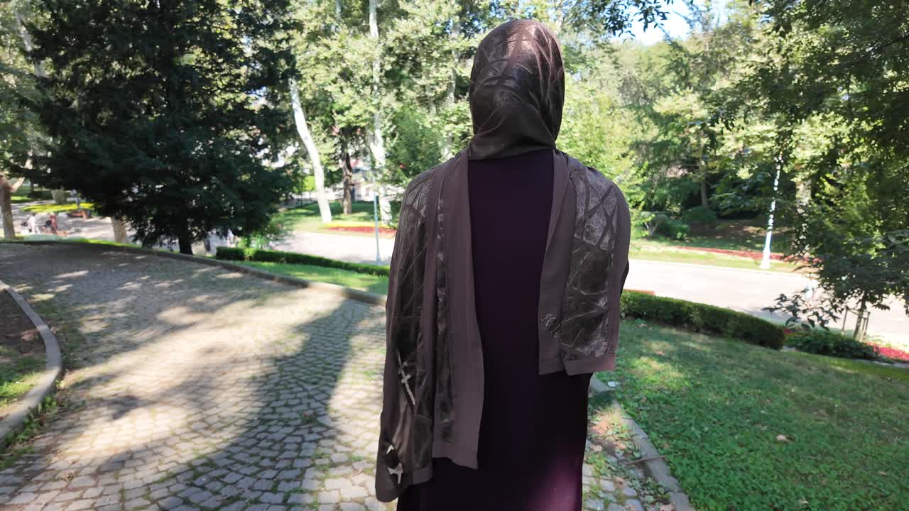 A woman in hijab standing in a park