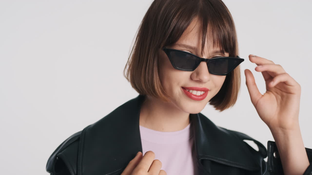 модель позирует и снимает солнцезащитные очки.