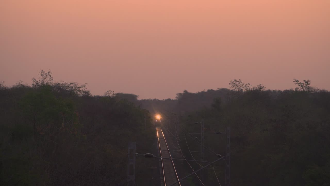 fotografía delantera del motor del tren de los ferrocarriles indios pasando por un túnel en la hora del amanecer en la india