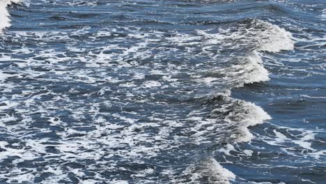 aerial view of turbulent ocean waves with dynamic movement and natural lighting, creating a dramatic and immersive seascape