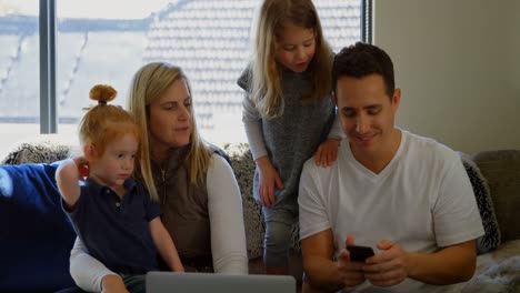 Family-using-mobile-phone-in-living-room-4k