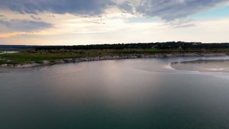 Wunderschöne-Luftaufnahme-über-Dem-Canyon-Lake-Mit-Majestätischen-Wolken-Im-Hintergrund-Und-Einer-Darstellung-Der-Texanischen-Hügellandschaft