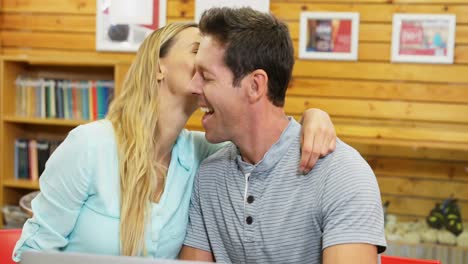 Couple-using-laptop-in-cafe-4k