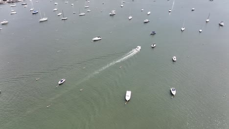 An-aerial-view-over-the-Northport-Marina-on-Long-island,-NY-with-several-anchored-boats-on-a-sunny-day