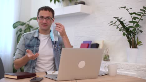 retrato de un joven empresario que se quita la máscara en el lugar de trabajo. trabajo seguro en tiempos de pandemia