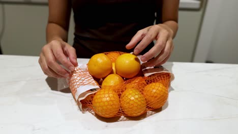 hands sorting oranges and lemons on a table