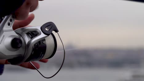 fishing rod and swing fishing with spinning on the sea. cloudy weather tying rope winter 4k view galata bridge in istanbul