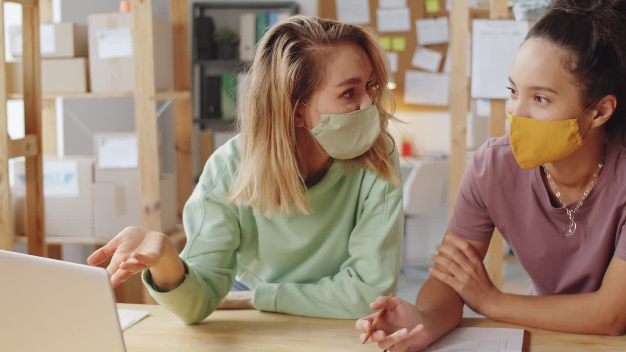 비즈니스 회의에서 마스크를 입은 두 명의 여성