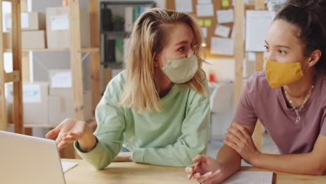 dos mujeres con máscaras en una reunión de negocios
