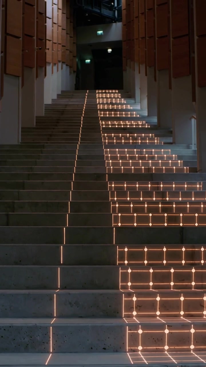 Vertikal video: Programmerede LED'er aktiverer noder og danner et stigende gitter, der guider op ad en betontrappe