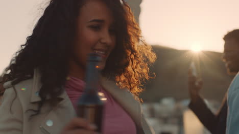 Mujer-Joven-Bailando-Grupo-De-Amigos-Diversos-Pasando-El-Rato-Juntos-Disfrutando-De-Una-Fiesta-En-La-Azotea-Al-Atardecer-Bebiendo-Alcohol-Divirtiéndose-En-La-Celebración-Del-Fin-De-Semana