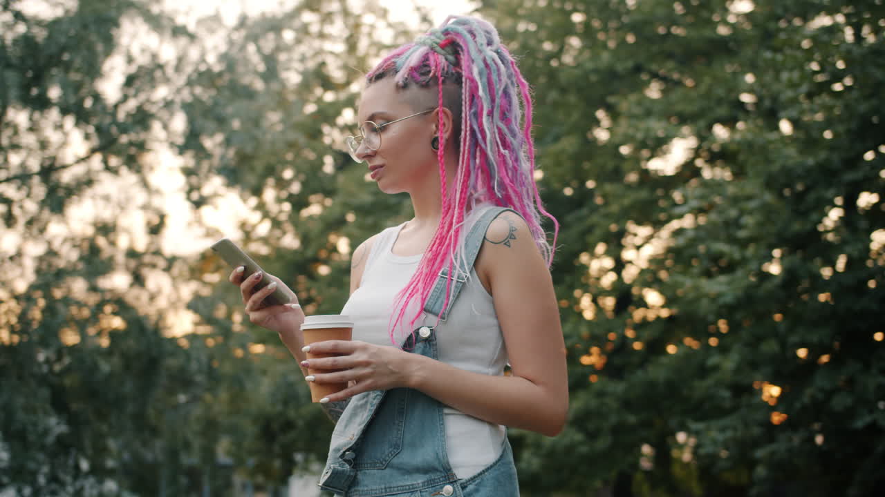 Woman with Pink Dreadlocks Using Phone in Park