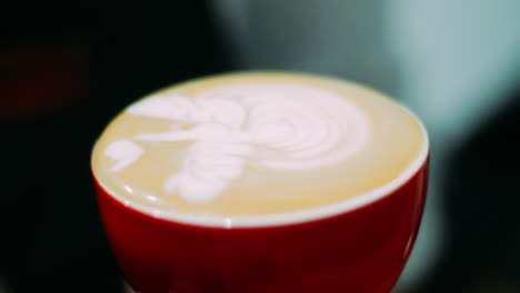 professional barista pouring milk into coffee cup making nice latte pattern