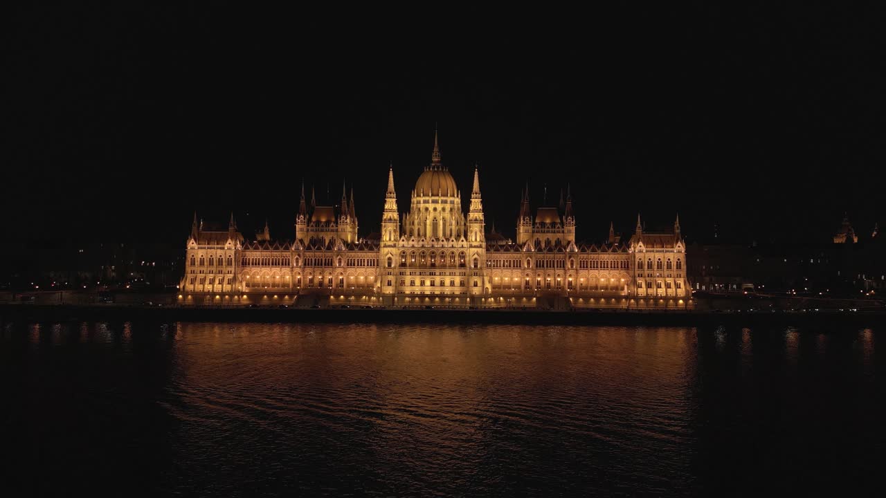 Ripresa aerea sopra il fiume Danubio con il Parlamento Ungherese sullo sfondo di notte