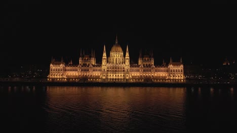 Boom-Shot-Above-Danube-River-with-Hungarian-Parliament-in-Background-at-Night