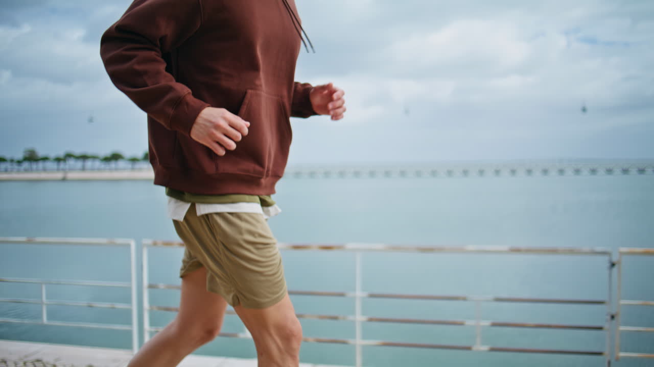 Runner body workout outdoors alone closeup. Strong man training at overcast bay