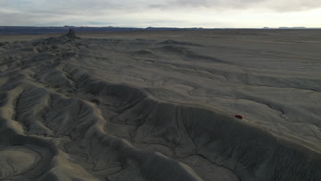 Aerial-View-of-Red-Vehicle-Moving-on-Sandstone-Hill-in-Desert-Landscape,-Drone-Shot