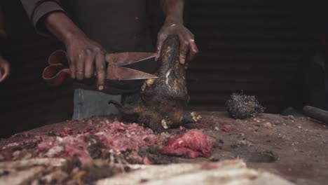 african man cutting meat with scissors