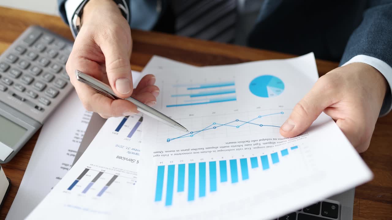 Businessman with pen in hand examining charts on documents closeup 4k movie slow motion