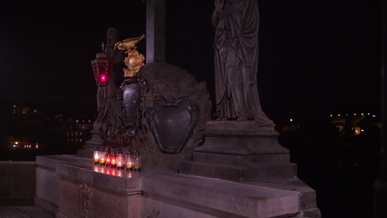 Golden eagle on Charles bridge Prague, Statuary of the St. Cross with Calvary in baroque style, gimbal shot, night scene with candles