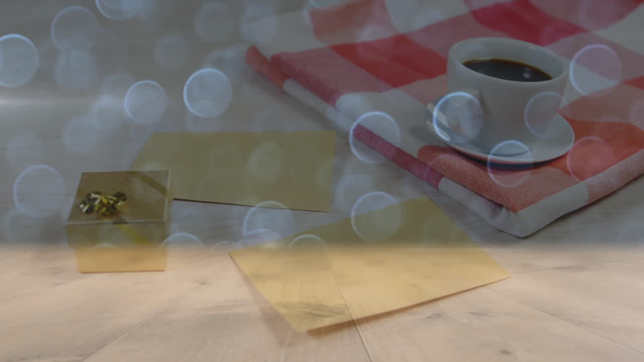 showing white ceramic coffee cup on checked napkin with golden envelopes under soft bokeh