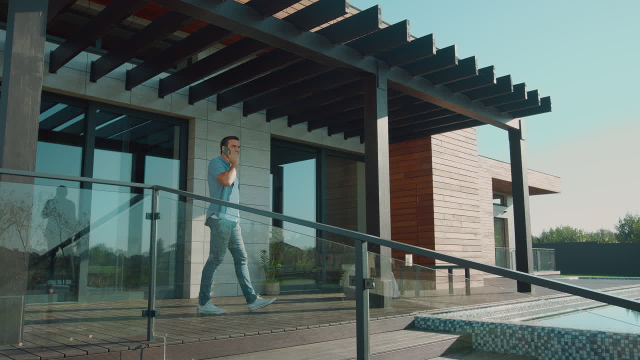 hombre de negocios hablando por móvil en una casa de lujo. hombre guapo hablando por móvil.