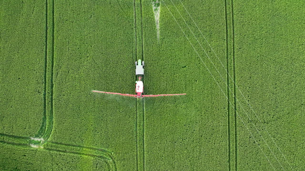 vista aérea de un campo de cultivo con un tractor rociando pesticidas