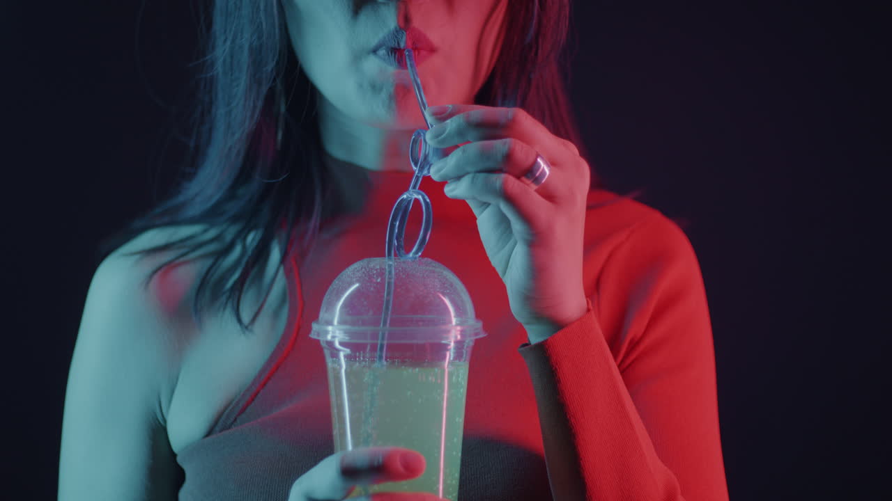 Woman Drinking Soda Under Neon Light