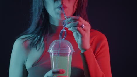 woman drinking soda under neon light
