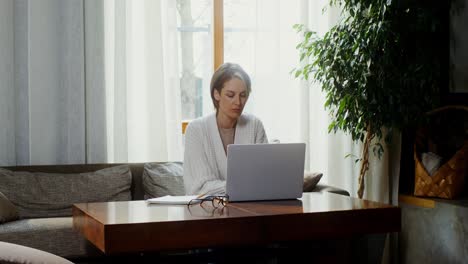 mujer trabajando desde casa en una computadora portátil