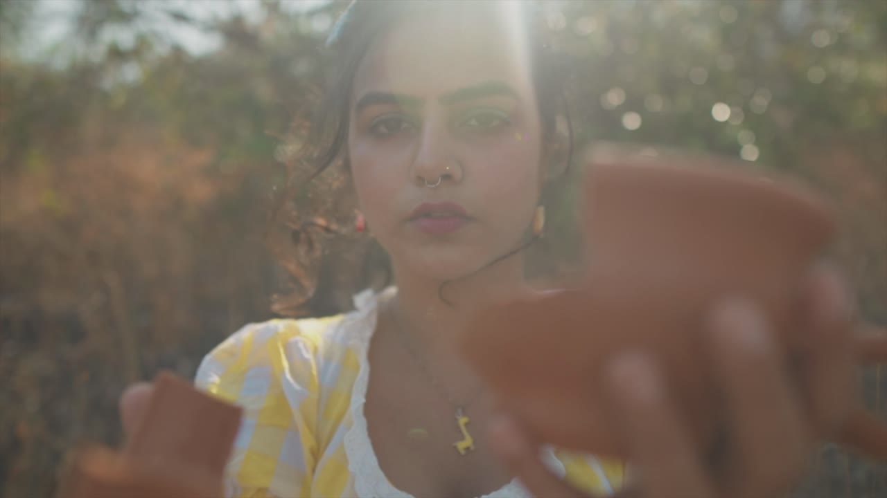 retrato de una chica atractiva mirando a la cámara, sosteniendo un jarrón de cerámica